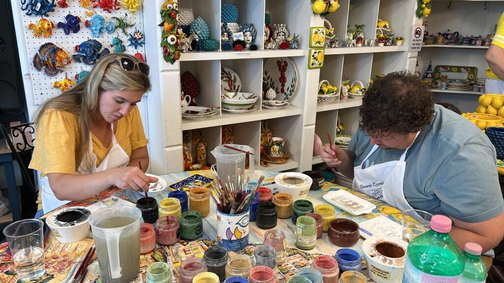 a couple painting ceramics
