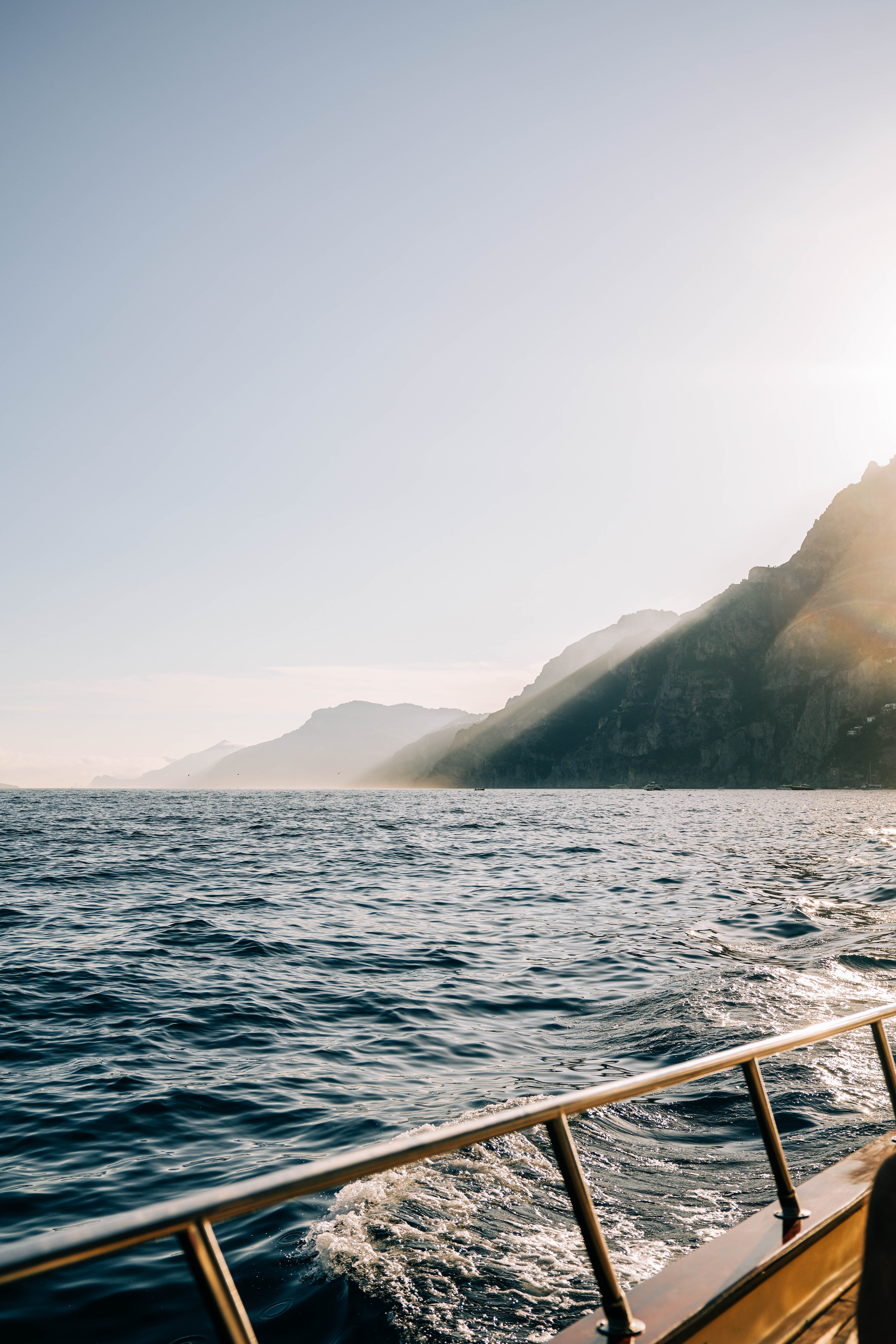 the sunset over the mountains in Amalfi from a boat in the sea