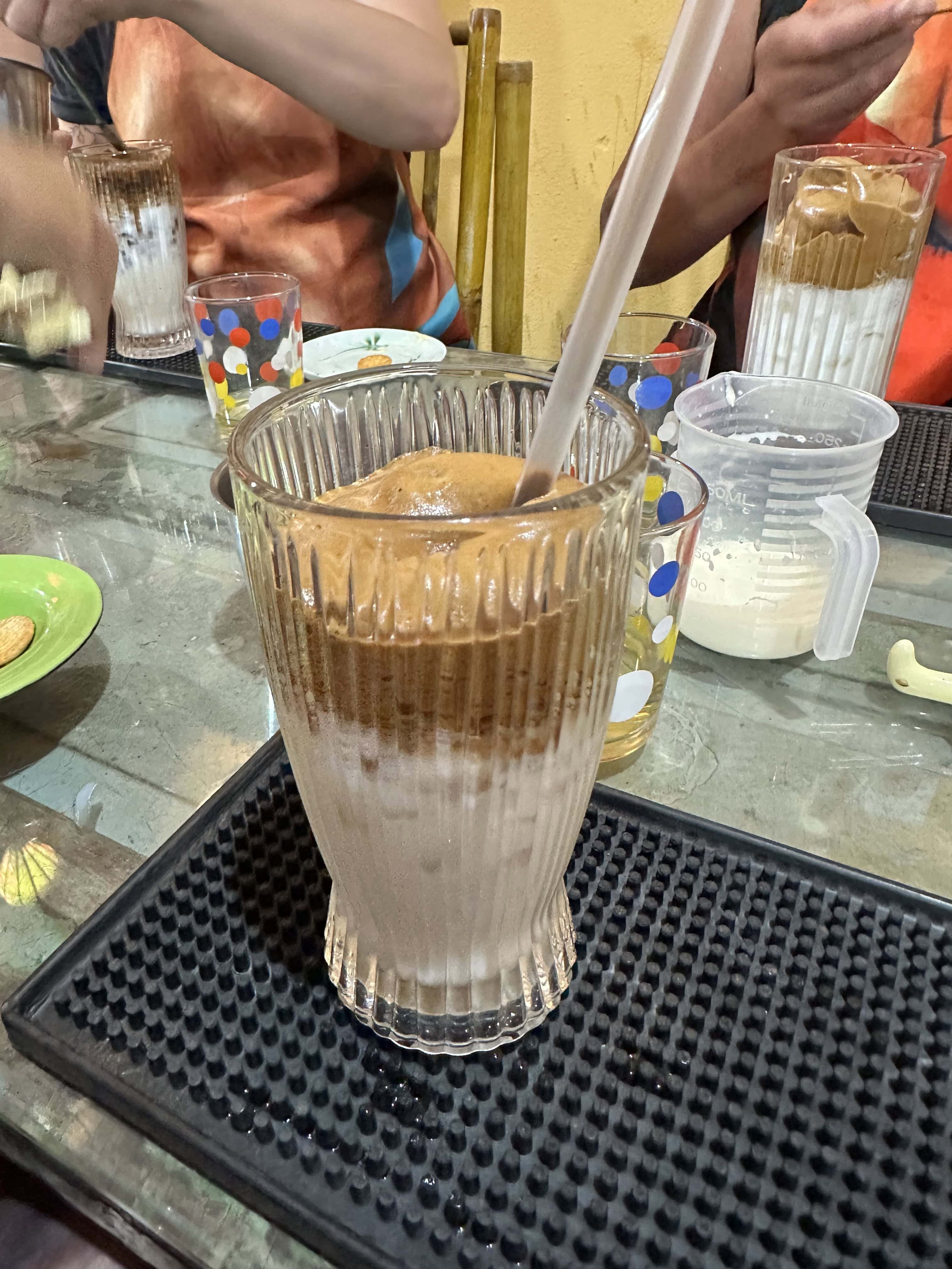 A cup with a very frothy coffee beverage