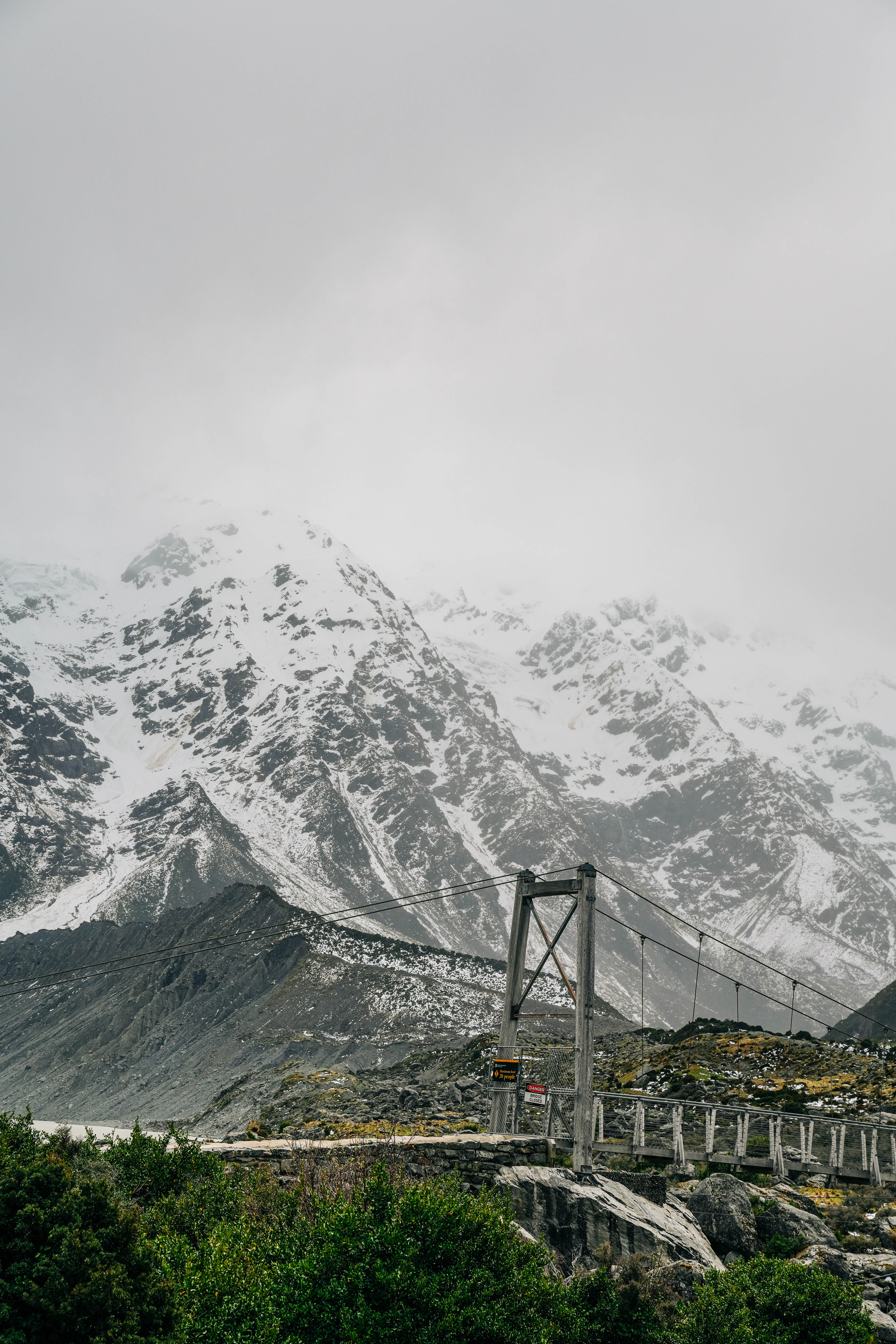 a view of New Zealand alpine mountains with a suspension bridge