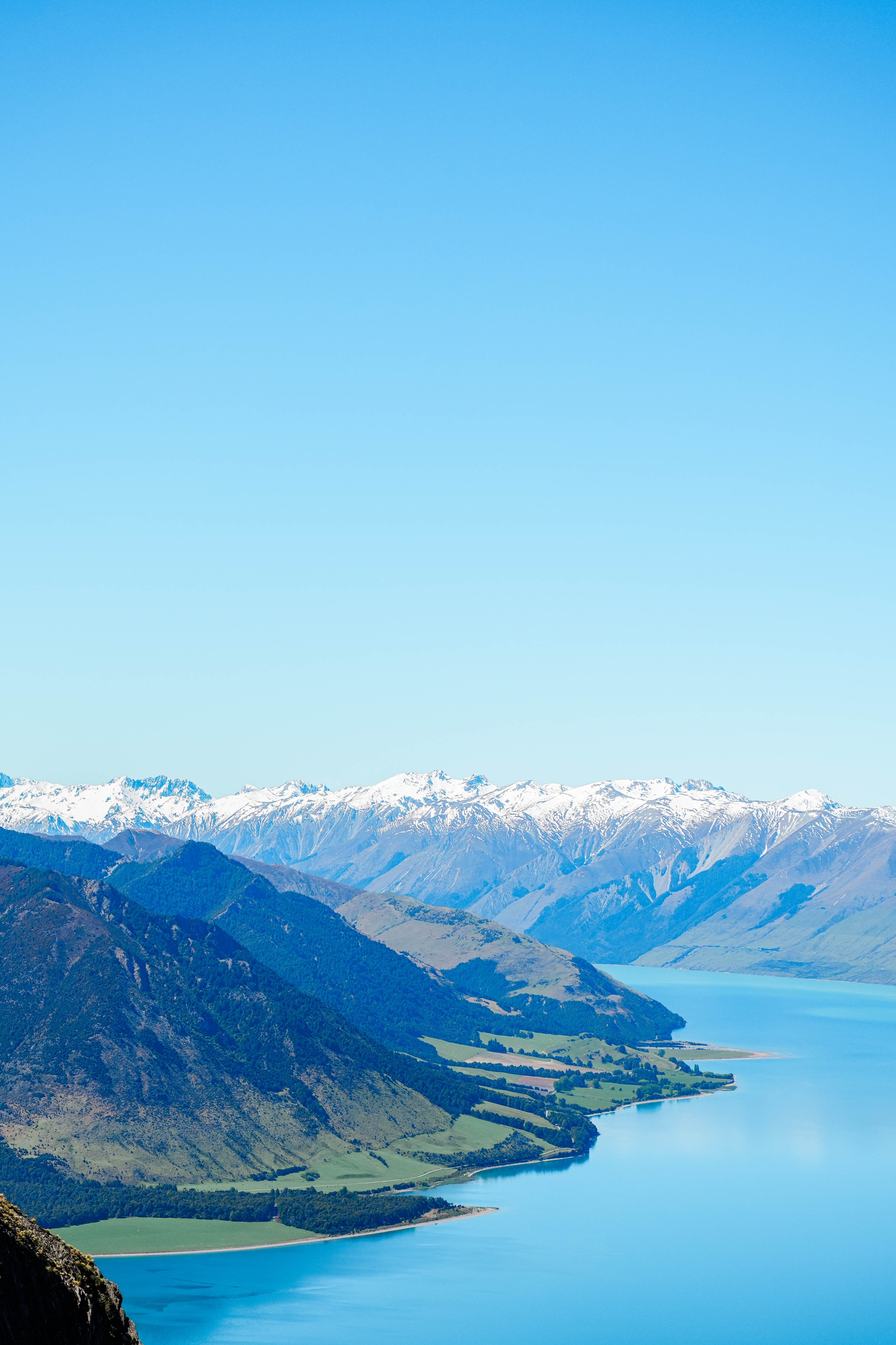 a view of a snow covered mountains and an alpine lake