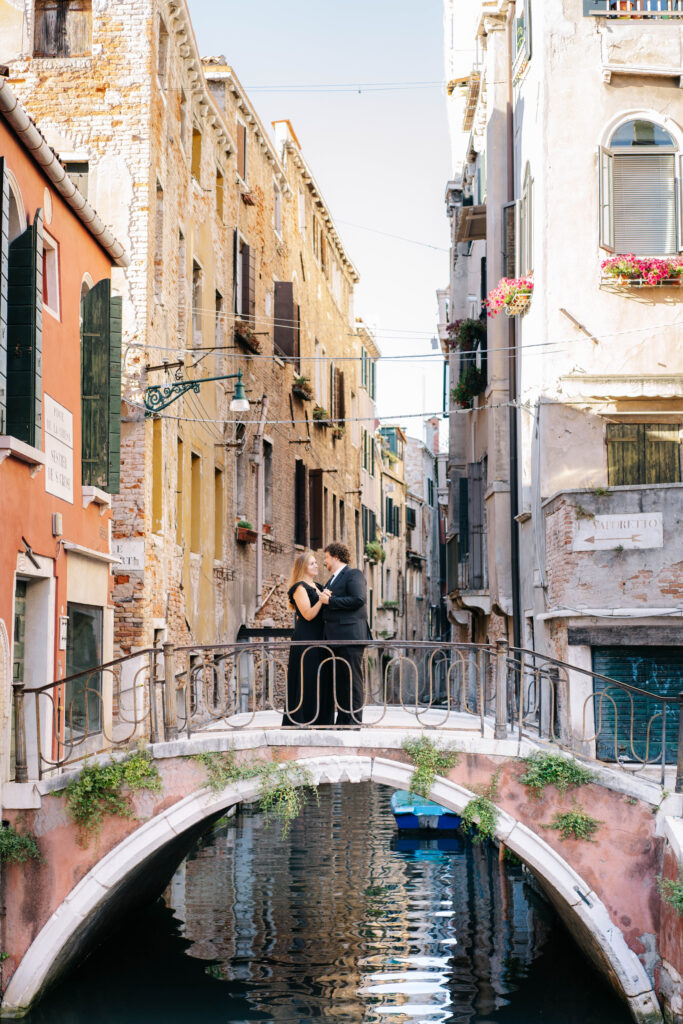 a couple embracing on a bridge in over a Venice canal