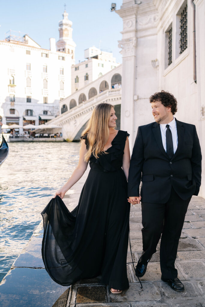 a couple holding hands along a river