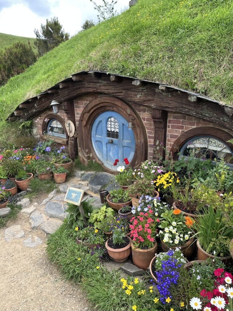 a hobbit house with flowers in front