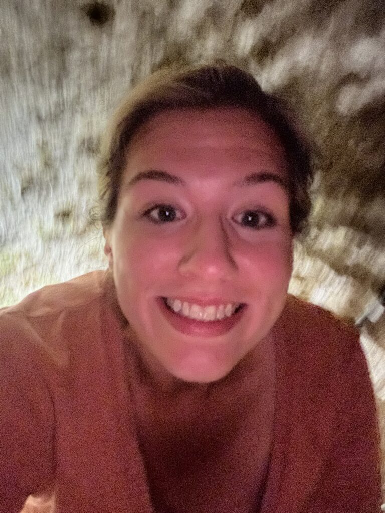 a woman crouching in a cave