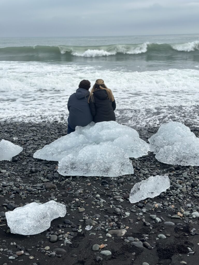a couple sitting on an large piece of ice