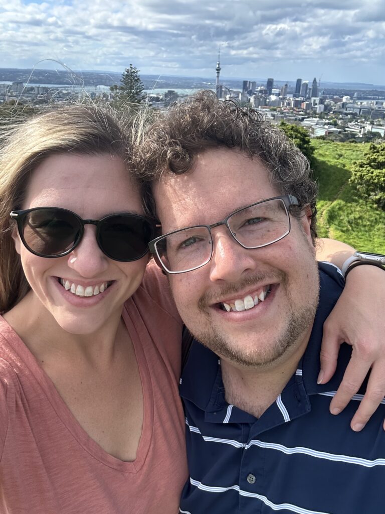 a couple embracing with a city behind them