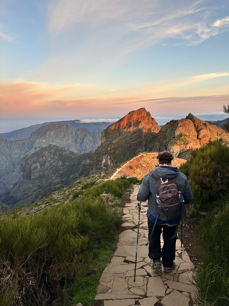 a man hiking in the mountains during sunrise