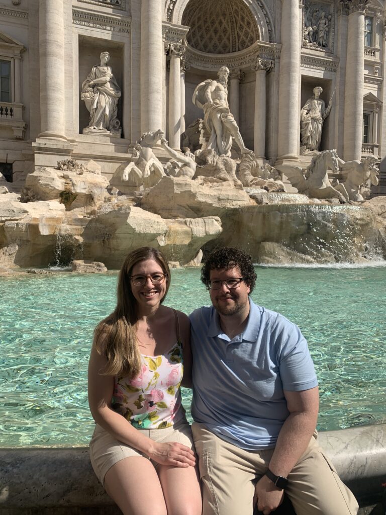 An image of a couple in front of the Trevi fountain