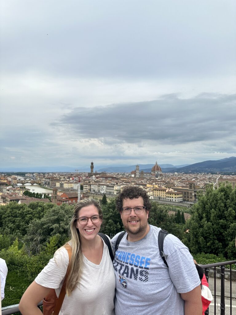 a couple posing with the Florence skyline behind them