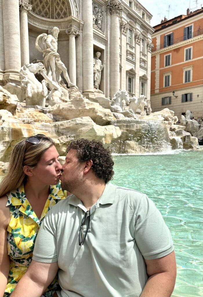 an image of a couple in front of the Trevi fountain