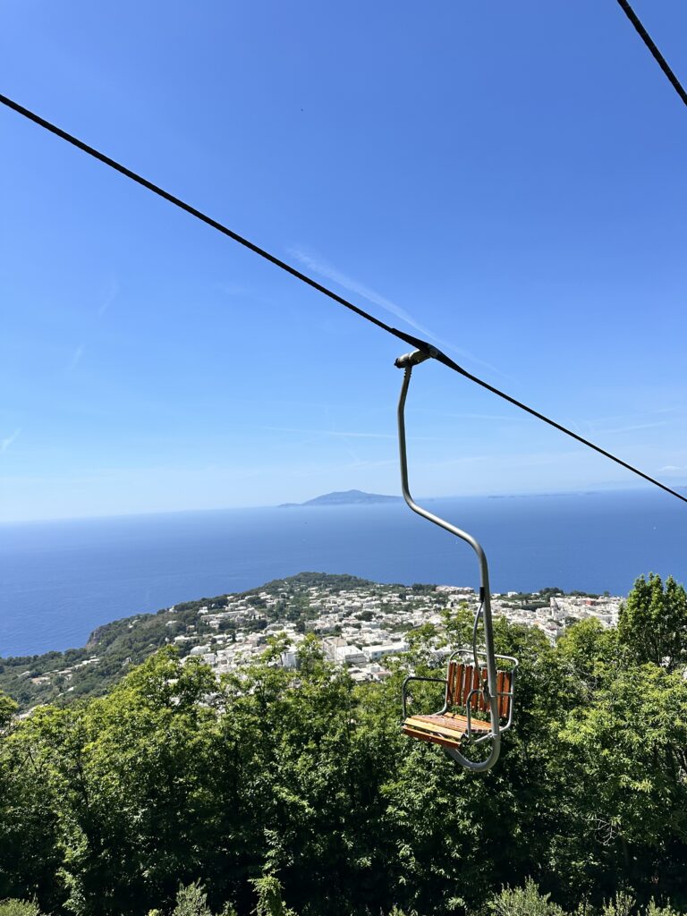 an empty chairlift with the sea in the background