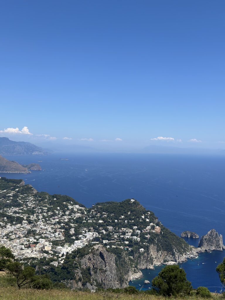 a view of the sea, an Italian village, and mountains